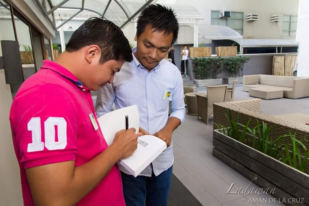 About 7 RM Nisperos signing a copy of the book Cyberpreneur Philippines for a reader