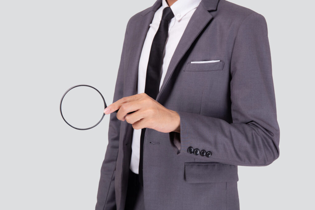 Man in suit holding magnifying glass